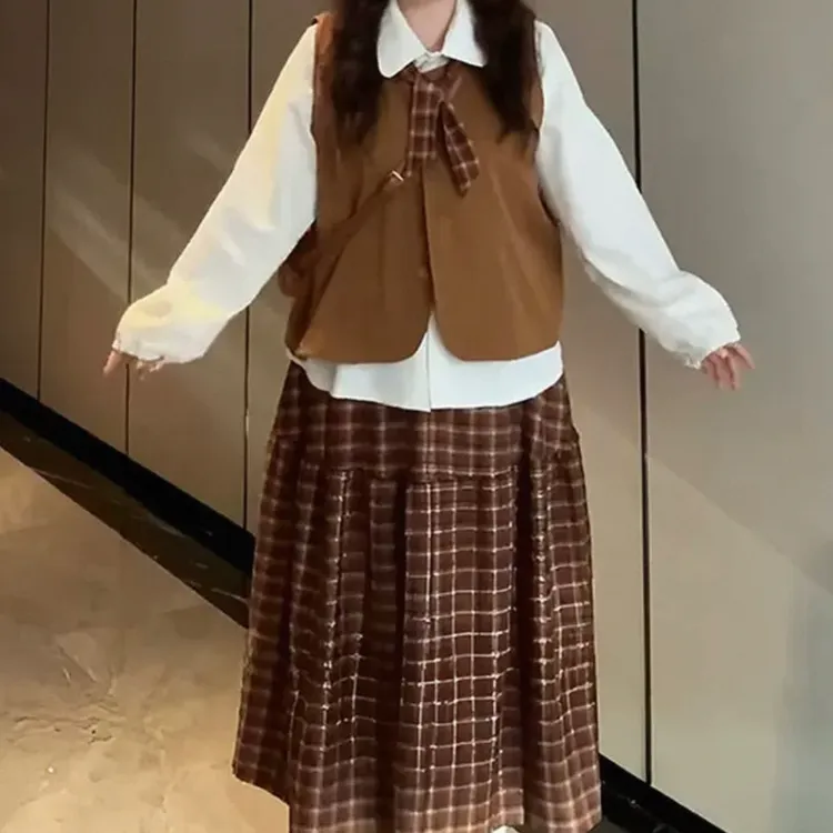 复古学院风格纹半身裙搭配卡其色马甲背心与杏色衬衫穿搭