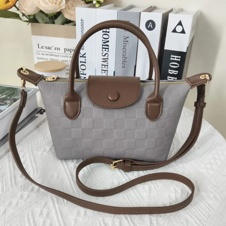 女包跨境通勤手提包包2025新款按扣女包士风饺子包单肩斜挎小方包