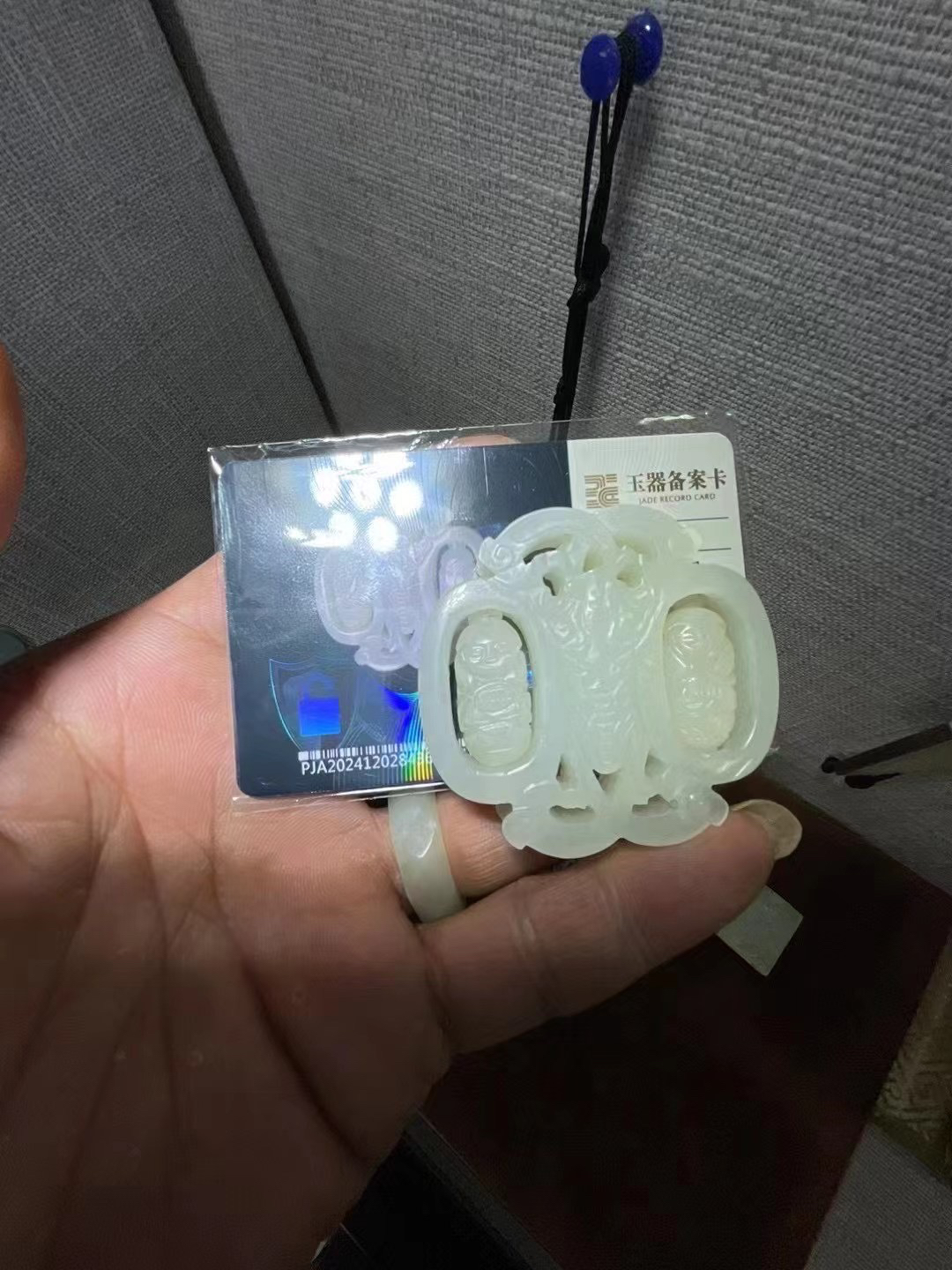 和田白玉和合童子福运叠至转心佩，玉润中华展出同款。带璞鉴卡