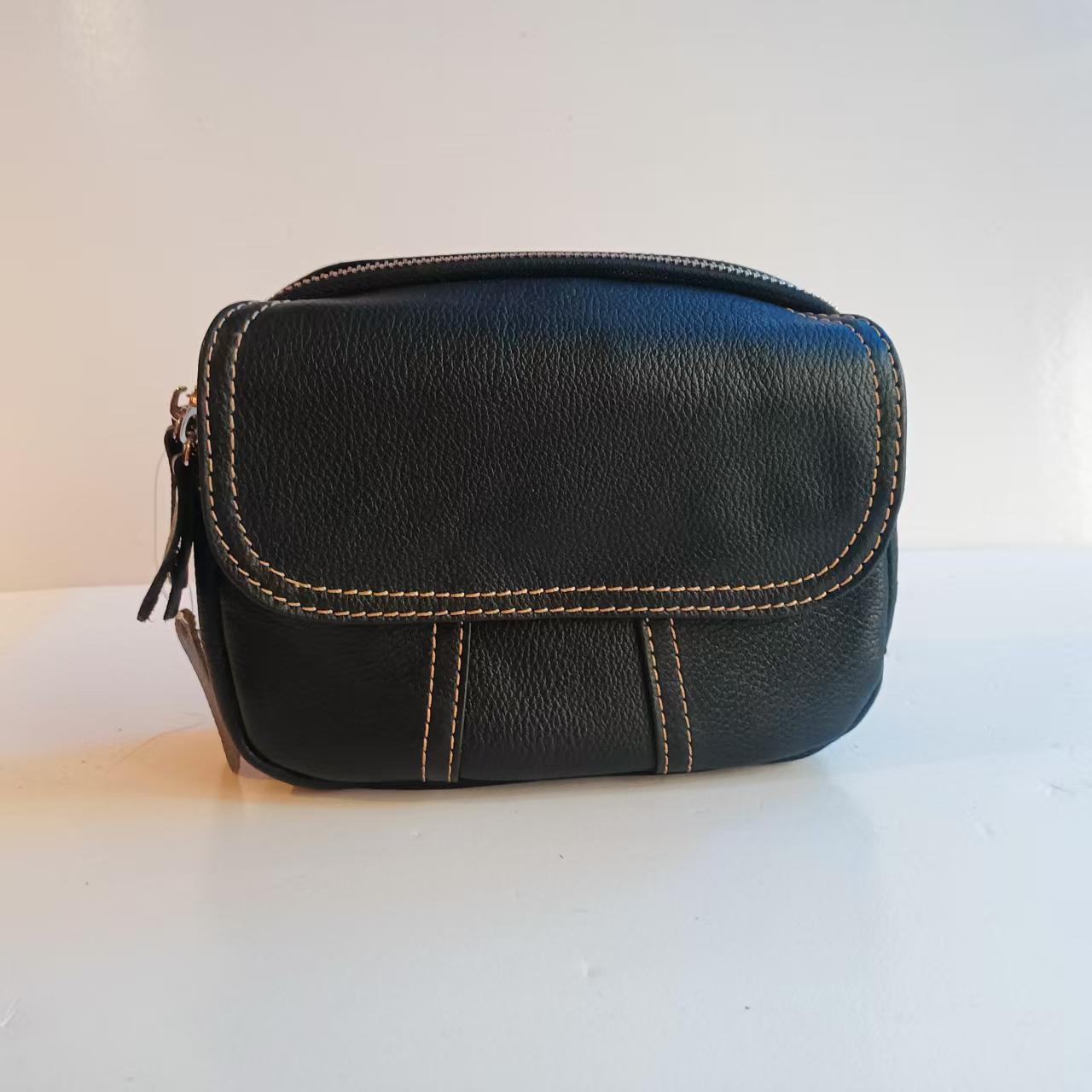 经典黑色，永不过时。这款真皮小包，独特的明线设计增添时尚感 。