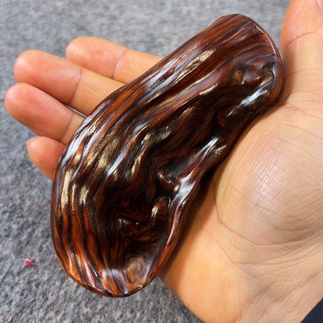 崖柏紫红糖化石骨把件 