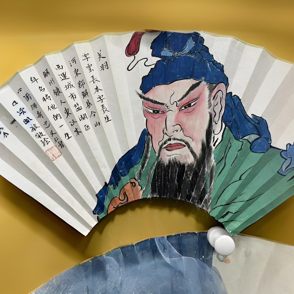 红脸关公，丹凤眼，卧蚕眉。苏工手绘宣纸折扇，水墨玉竹扇骨。