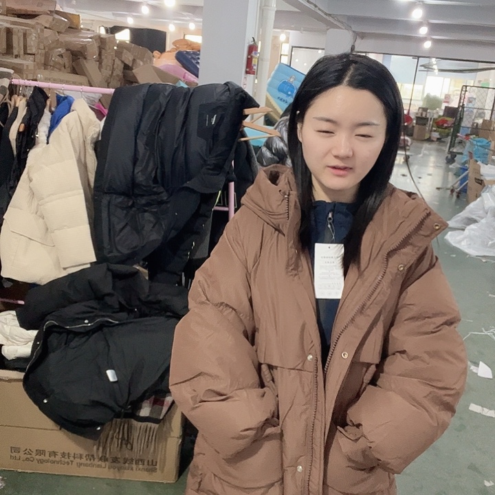 棕色长款外套。L啦啦啦啦