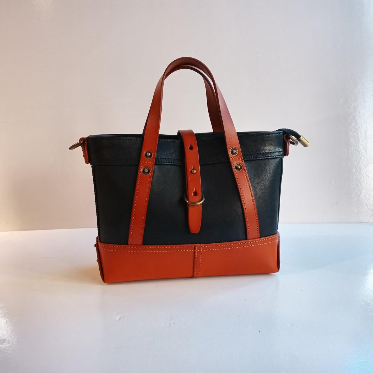黑与橙的撞色设计，让这款手提包个性十足。金属配件点缀，复古。