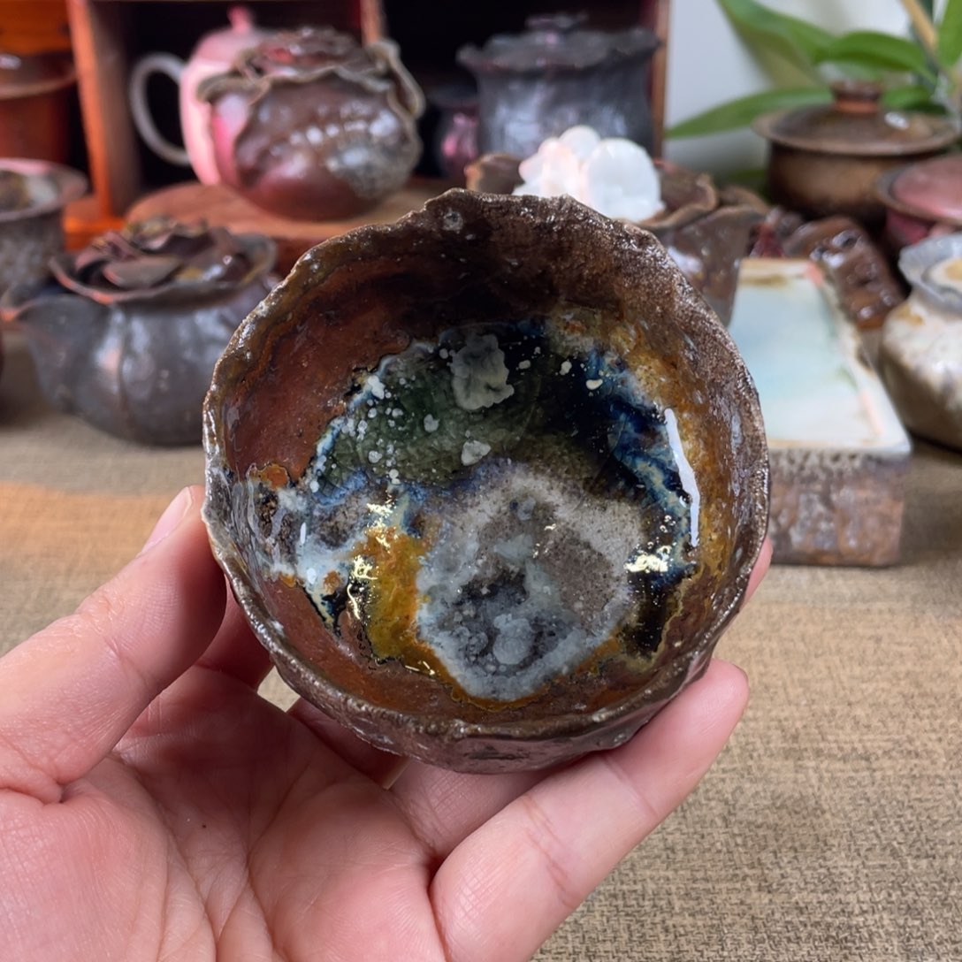 魏*欣手捏柴烧。    手捏杯原矿