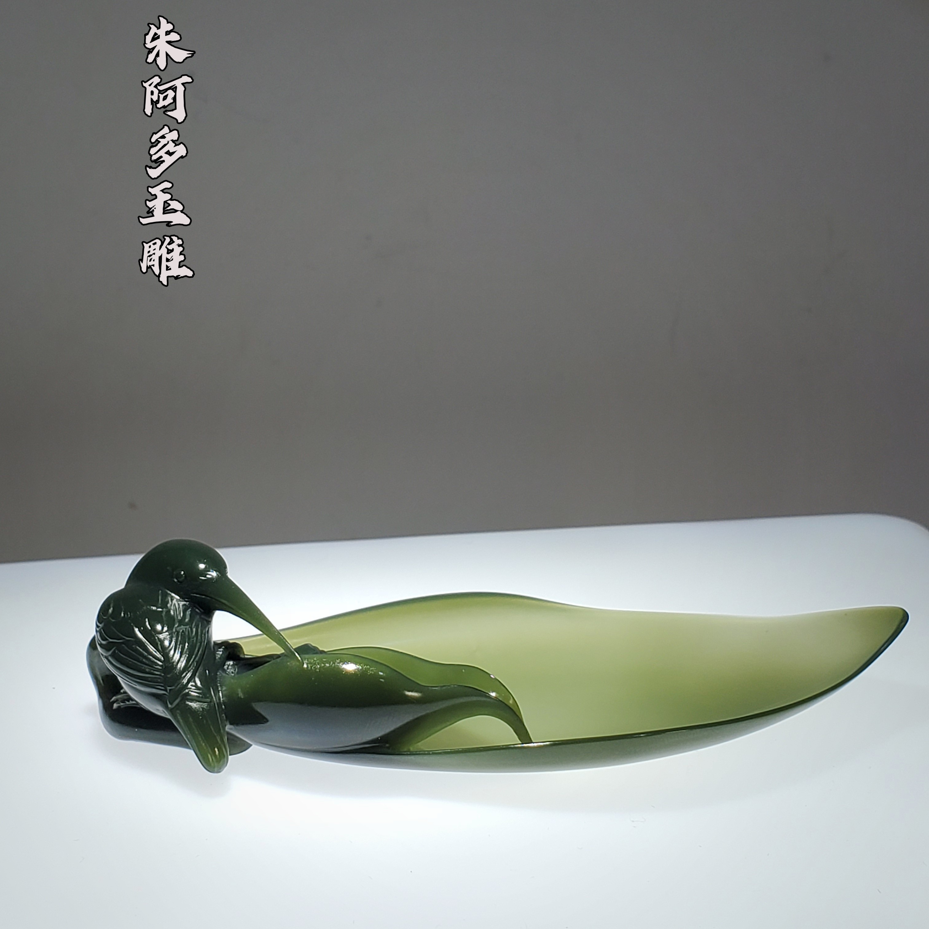 朱阿多工艺极细青玉茶则，雕工精妙，翠鸟栩栩如生，以莲花作题材